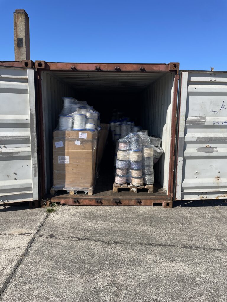 Seecontainer mit eingelagerten Waren und Paletten